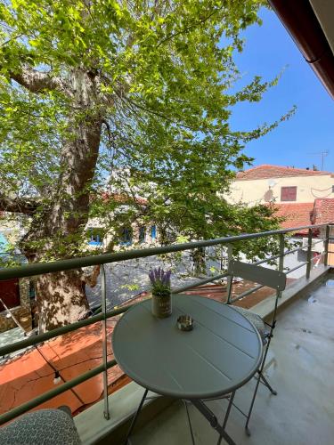 a table and chairs on a balcony with a tree at Plane Tree House in Próti
