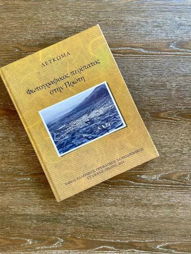 a book sitting on top of a wooden table at Plane Tree House in Próti