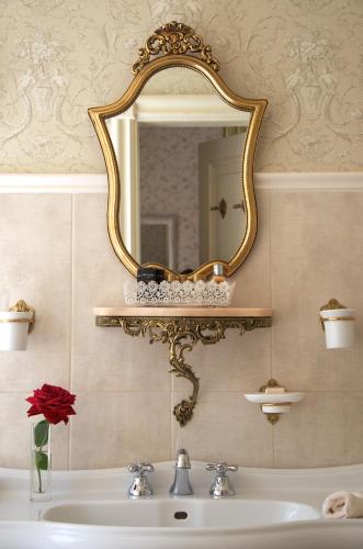 a bathroom with a sink and a mirror on the wall at Liepupe Manor in Liepupe