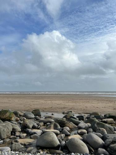 a large group of rocks on a beach at Tŷ Jones Amroth Bay in Amroth