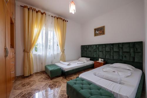 サランダにあるDuraj Apartmentのベッドルーム1室(ベッド2台、緑のソファ付)