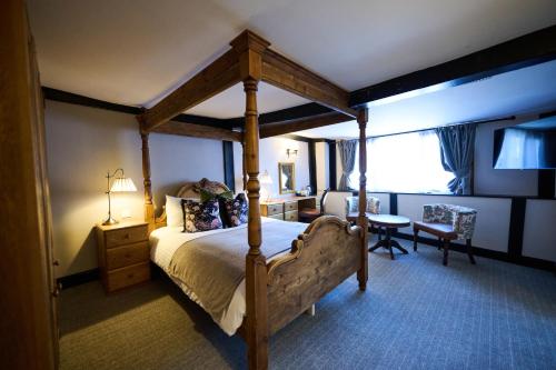 a bedroom with a canopy bed and a desk at White Hart, Exeter by Marston's Inns in Exeter