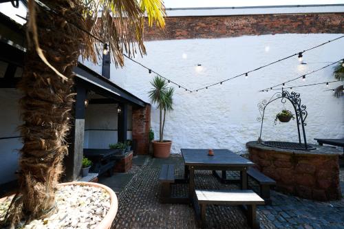 a patio with a table and benches and a building at White Hart, Exeter by Marston's Inns in Exeter