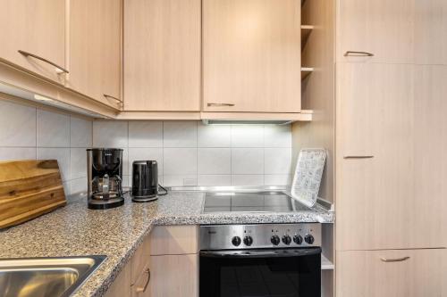 a kitchen with wooden cabinets and a stove top oven at Fewo Willingenliebe Meinecardplus in Willingen