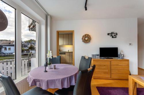a small dining room with a table and a television at Fewo Willingenliebe Meinecardplus in Willingen