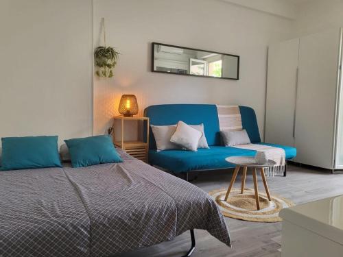 - une chambre avec un lit bleu et un canapé dans l'établissement Appartement Juan Les Pins à 2 min de la plage, à Antibes