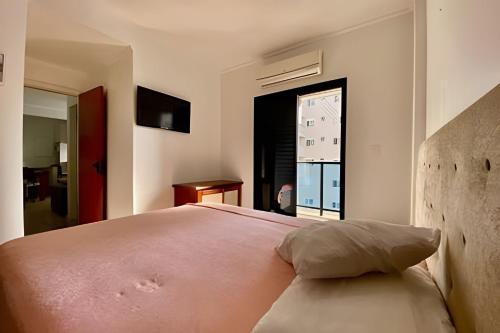 a bedroom with a large bed and a window at SHB - The Jewel Pitangueiras with complete leisure in Guarujá
