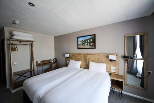 a bedroom with a large white bed and a mirror at White Hart, Exeter by Marston's Inns in Exeter