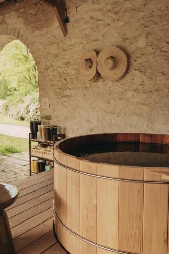 un grand tonneau en bois posé sur une terrasse avec des chaises dans l'établissement Maison proche de Paris, La Source, à Châlo-Saint-Mars