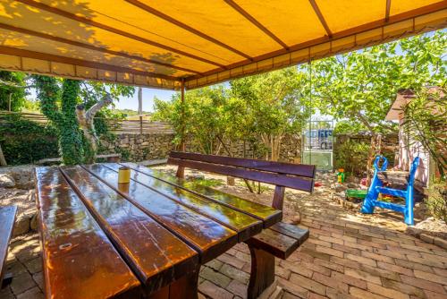 a wooden picnic table sitting under a yellow umbrella at Holiday apartment WATERFRONT by the sea in Klimno
