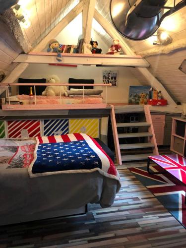 Cette chambre comprend un lit avec une couverture américaine. dans l'établissement Maison atypique 3 chambres, à Requeil