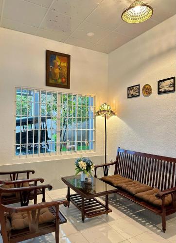 a living room with benches and a table and a window at Tiami Eden Villa - Nghỉ Dưỡng Sân Vườn Ven Biển in Vung Tau