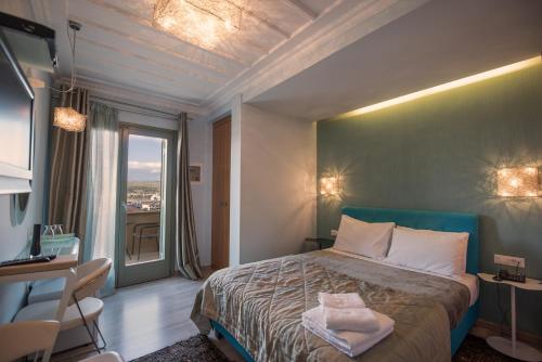 a bedroom with a bed and a desk and a window at Amfitriti Palazzo in Nafplio
