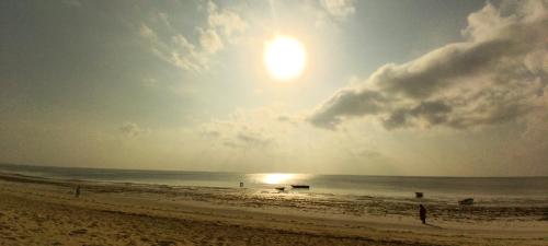 a beach with the sun rising over the ocean at Swahili Palace Zanzibar in Pwani Mchangani