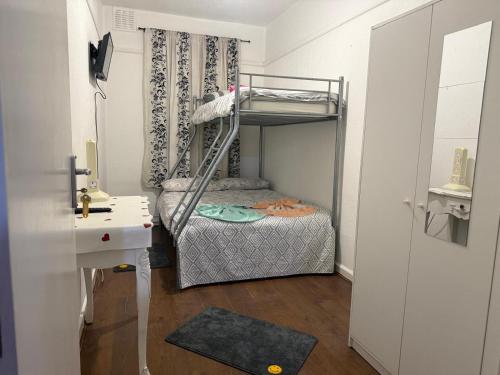 a small room with a bunk bed and a desk at Britannia Stay Stockwell - 13 min to Oxford Circus in London