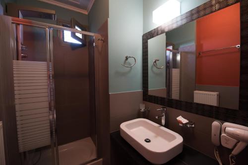a bathroom with a sink and a toilet and a mirror at Amfitriti Palazzo in Nafplio