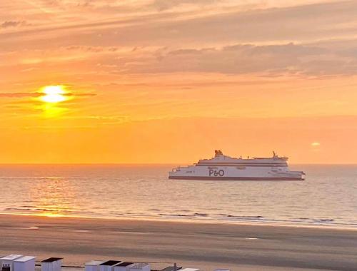 un bateau de croisière dans l'océan au coucher du soleil dans l'établissement Studio au front de mer , Plage de Calais, à Calais
