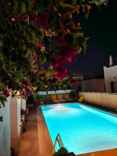 a swimming pool with flowers on the side of a building at Berg Pansiyon in Bodrum City