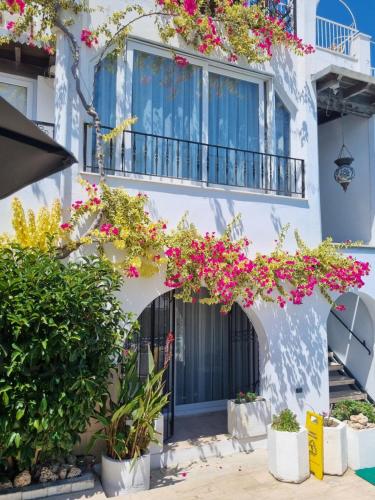 a white building with flowers on the balcony at Berg Pansiyon in Bodrum City