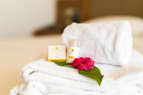 a pile of towels with a pink flower on top at Sol Azur in Hammamet