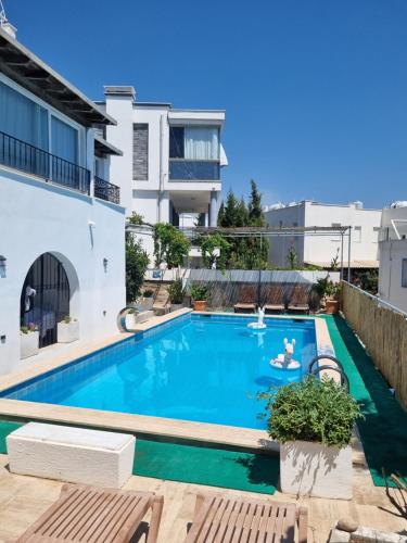 a swimming pool in front of a building at Berg Pansiyon in Bodrum City