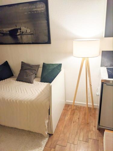 - une chambre avec un lit et une lampe dans l'établissement Quiet Intramuros Studio in Secure Residence, à Avignon