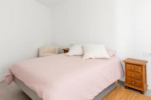 ein weißes Bett mit zwei Kissen und einen Nachttisch in der Unterkunft Sunset Horizon Hideaway & Terrace, Santa Úrsula in Santa Úrsula