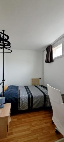 une chambre avec un lit, un bureau et une chaise dans l'établissement 2-room apartment with balcony Montparnasse, à Paris