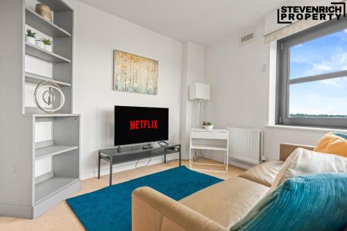a living room with a couch and a tv at Central Reading, 2 Bedroom Apartment, Secure Parking, Skyline View in Reading
