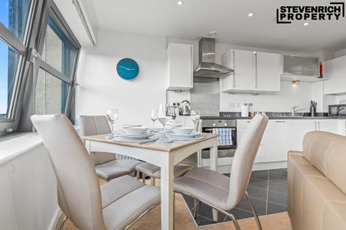 a kitchen and dining room with a table and chairs at Central Reading, 2 Bedroom Apartment, Secure Parking, Skyline View in Reading