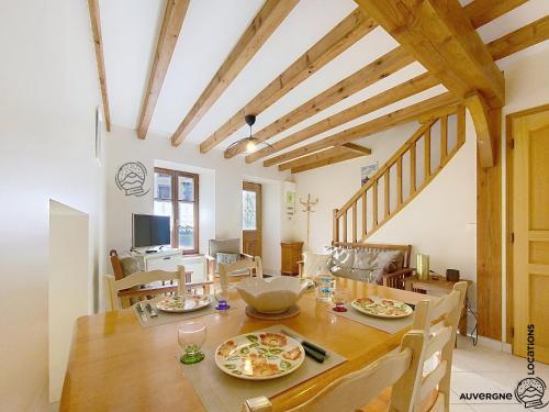 une salle à manger avec une table et des assiettes de nourriture dans l'établissement La Petite Barriade, à Saint-Nectaire