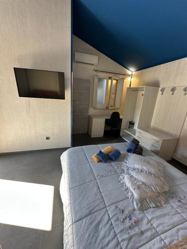 a large white bed in a room with a tv at Soulmondo Beach Rooms in Campomarino