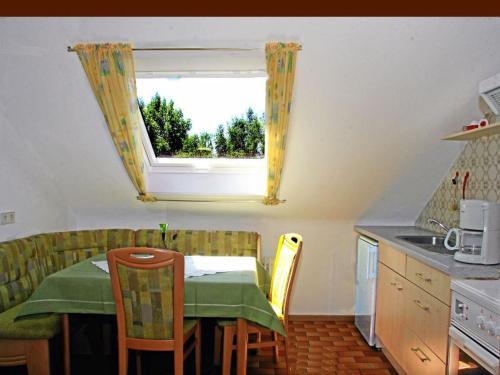 Una pequeña cocina con una mesa y una ventana. en Ferienwohnung Kaiserstuhlblick, en Burkheim