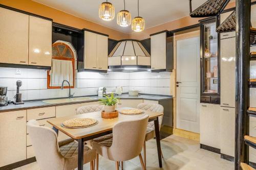 JK 7towers 1894 Cozy Maisonette -100m2 - Old City في سلانيك: مطبخ مع طاولة وكراسي خشبية