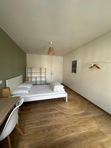 une chambre avec un lit blanc et un parquet dans l'établissement Chambres 20m2, SDB PV, Centre, WIFI, Appart 160m2, à Tourcoing