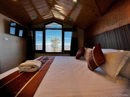 a large bed in a room with a window at Nirvana Rooms near Mall Road in Shimla