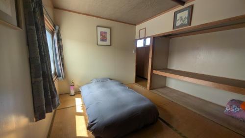 a bedroom with a large bed in the corner of a room at Taisetsu Art Stay in Kamikawa