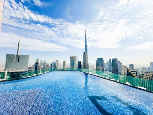 a swimming pool on the roof of a building with a city skyline at New Luxury 2 Bedroom with Burj Khalifa View & Spectacular Rooftop Infinity Pool Bar in Dubai