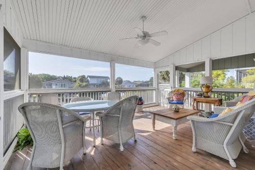 a screened in porch with a table and chairs at Sleeps 24 Waterfront Dock Golf Cart Walk to Beach in Pawleys Island