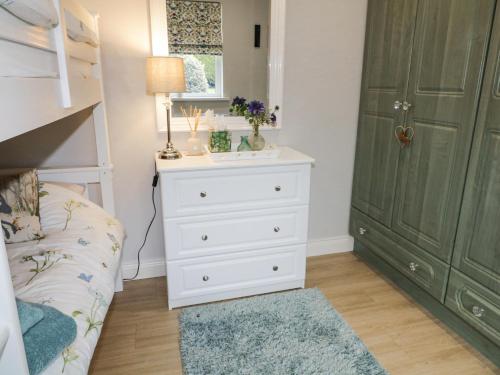 a bedroom with a white dresser and a green door at Shirley's House in Omagh