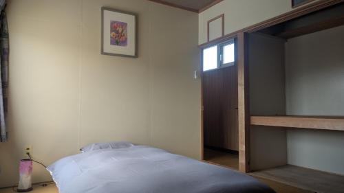 a bedroom with a bed and a bunk room with a ladder at Taisetsu Art Stay in Kamikawa