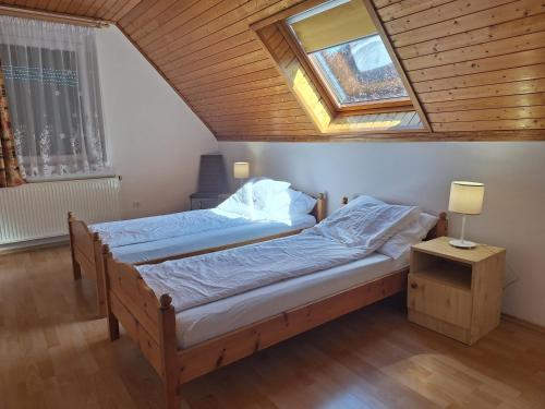 a bedroom with two beds and a skylight at Badacsony Apartmanház in Badacsonytomaj