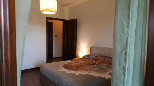 a bedroom with a bed in a room with a lamp at Casa della Nonna Rooms in Noventa di Piave