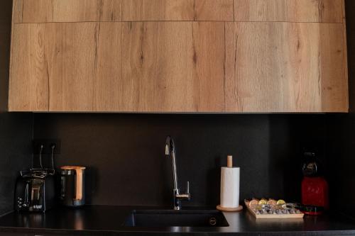 a kitchen counter with a sink and a wooden cabinet at Suite Haus Castelar in Santander
