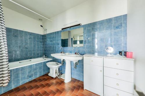 a blue tiled bathroom with a sink and a tub at Maison avec jardin pour 10 - 600m plage in Arzon
