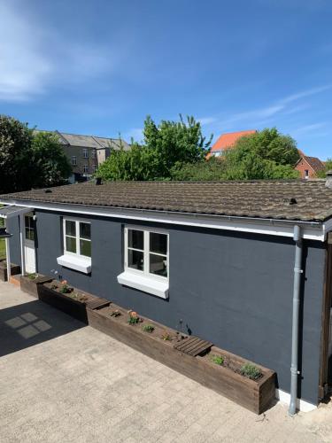 a gray house with two windows and a roof at H C Andersen city apartment in Odense