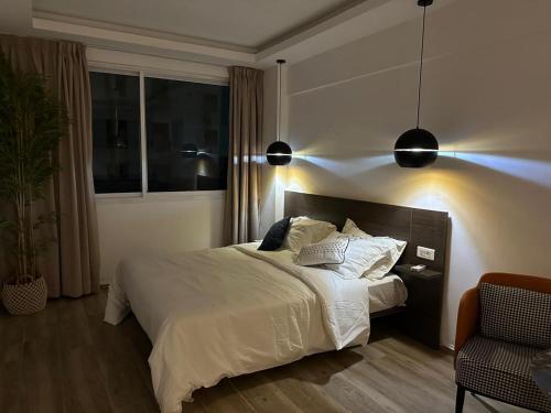 a bedroom with a large bed with white sheets and pillows at Bark Luxury Appartments @Signal Abidjan Plateau in Abidjan