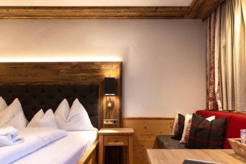 a hotel room with a bed and a couch at Hotel Spielmann in Ehrwald