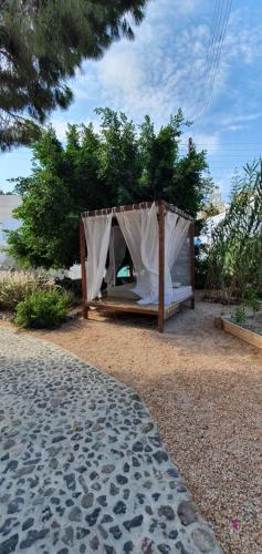 a canopy bed on the beach near the ocean at Kalitsi Canaves in Vóthon