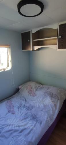a small bedroom with a bed in a tiny house at Holenderka Artur in Stegers